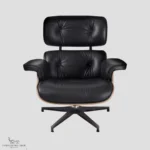 Full set view of a walnut and black leather Eames lounge chair knock off in a studio setting.