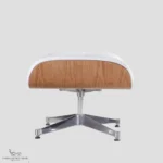 Close-up of an Eames style chair ottoman with a polished chrome base and ash wood veneer.